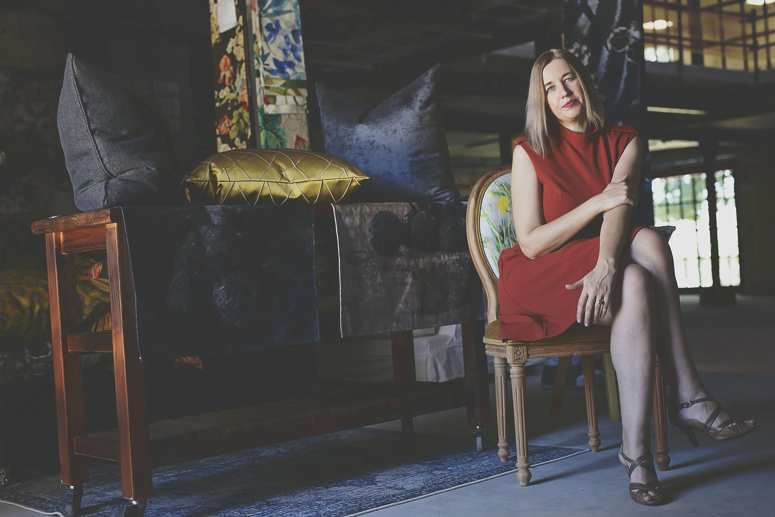Composer Kathleen Tagg in a red dress, seated in an antique chair